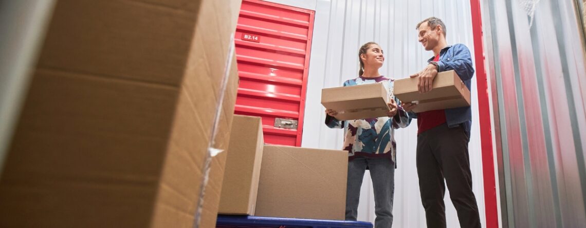 Couple carrying boxes into a storage unit