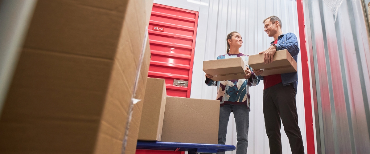 Couple carrying boxes into a storage unit