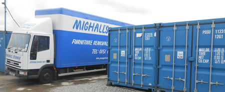 Removal lorry unloading next to blue shipping container storage units